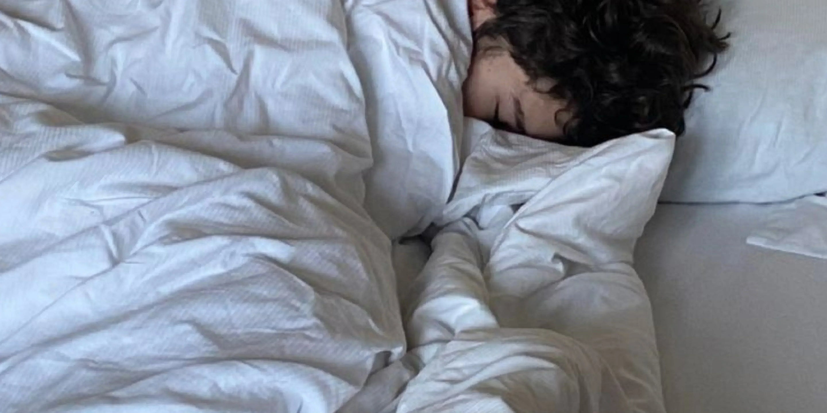 Homme qui dors avec une couette lestée