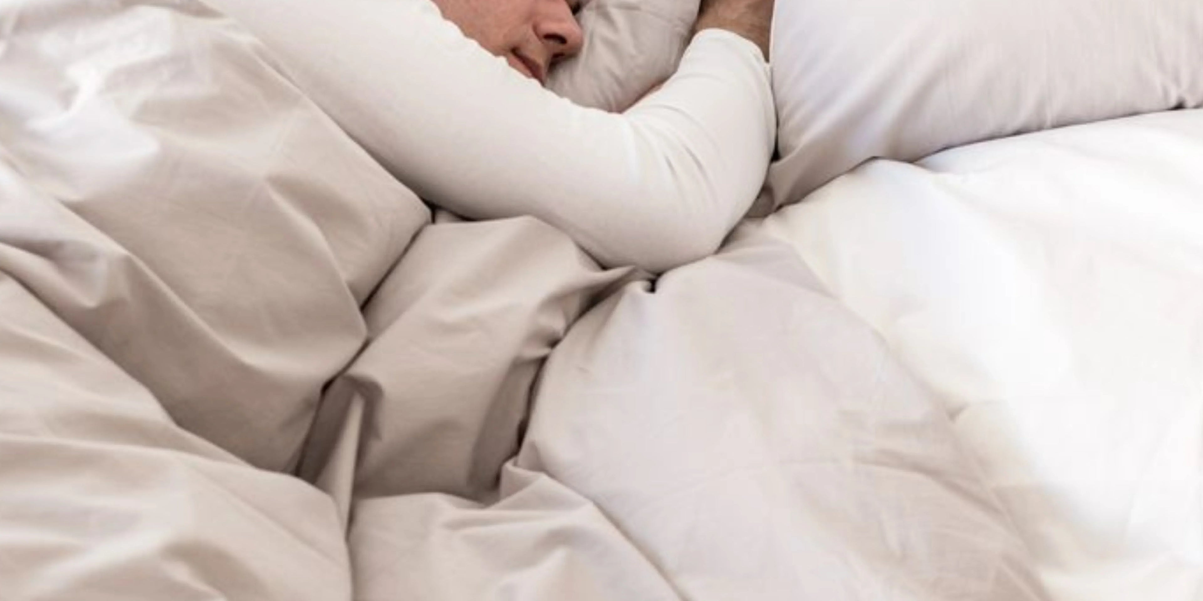 Homme qui dors avec couette lestée blanche Image